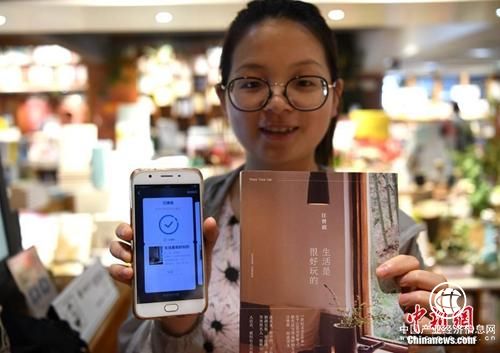 資料圖：讀者展示自己借閱的書籍。 <a target=